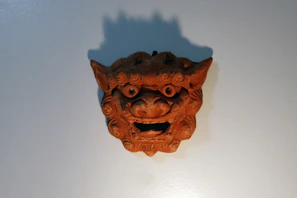 Intricately carved Lega wooden mask with rich patina reflecting ancestral spirits.