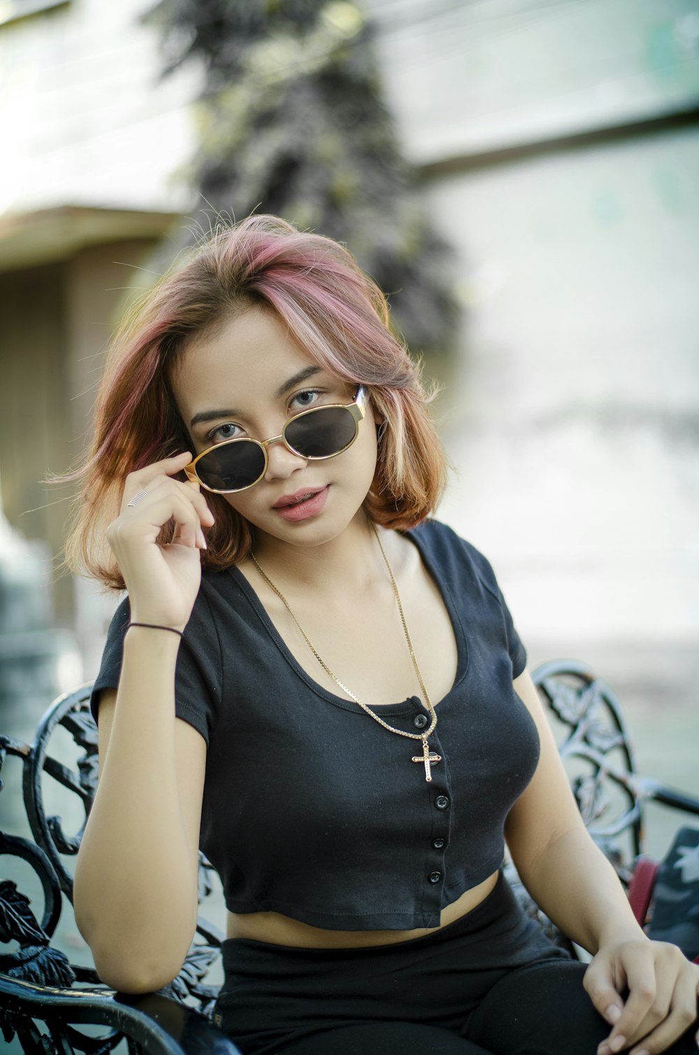 a woman sitting on a bench wearing sunglasses