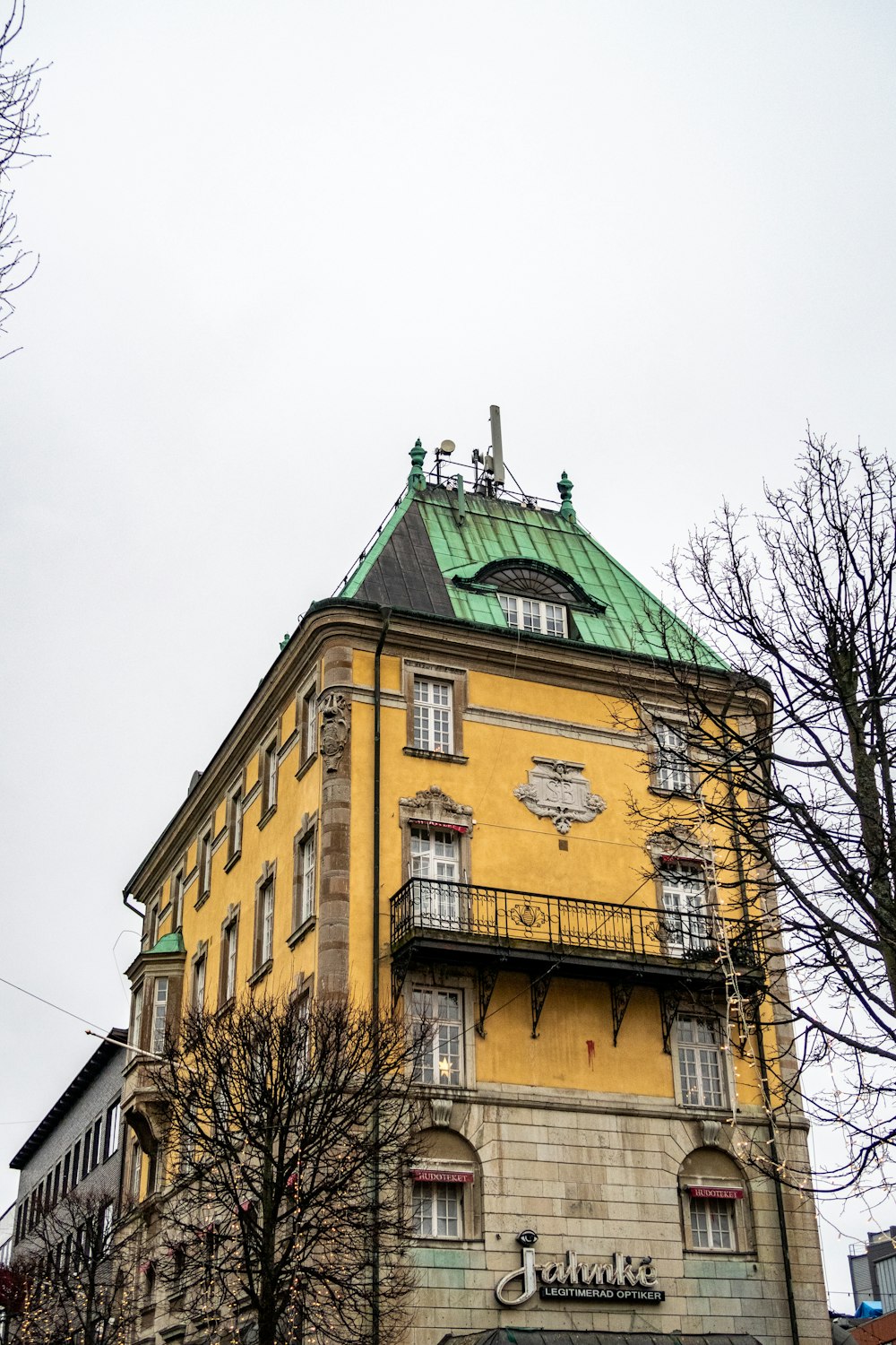 Un alto edificio amarillo con un techo verde