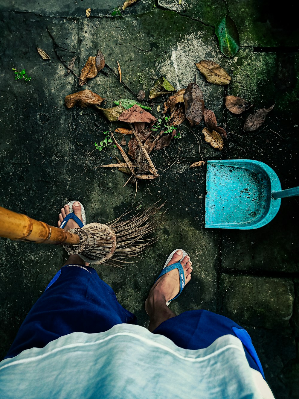 a person standing next to a blue shovel
