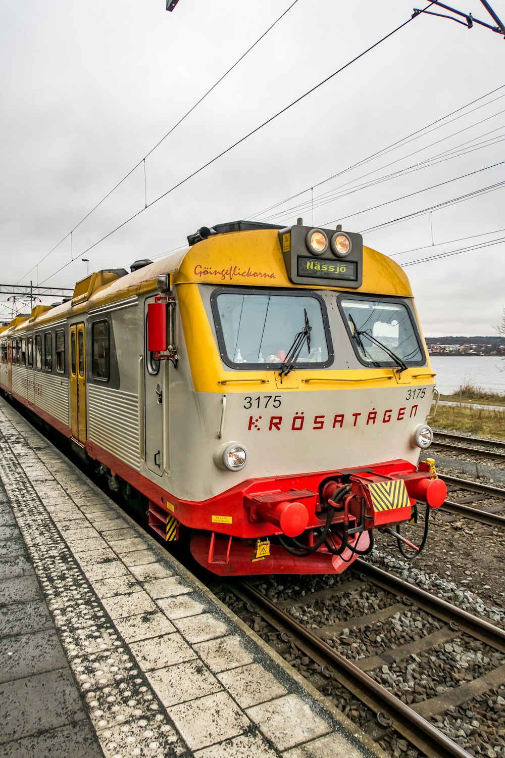 a yellow and white train traveling down train tracks