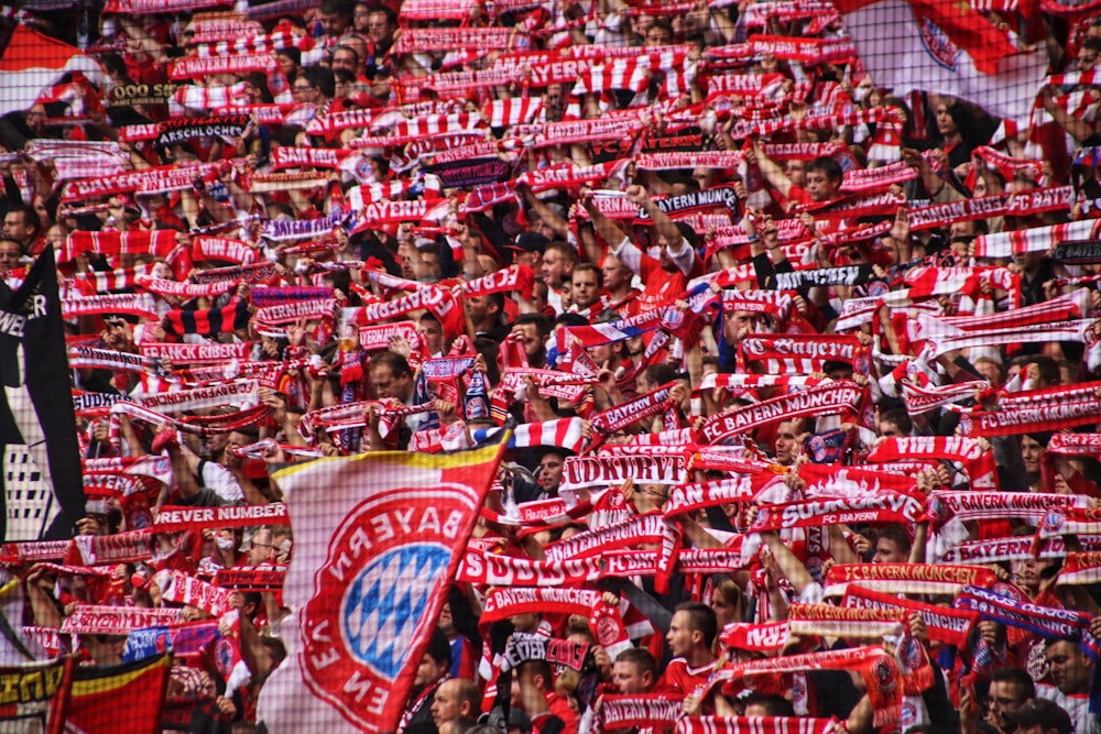 a large group of people holding red and white flags