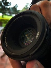 a close up of a person holding a camera lens