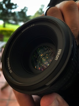 a close up of a person holding a camera lens