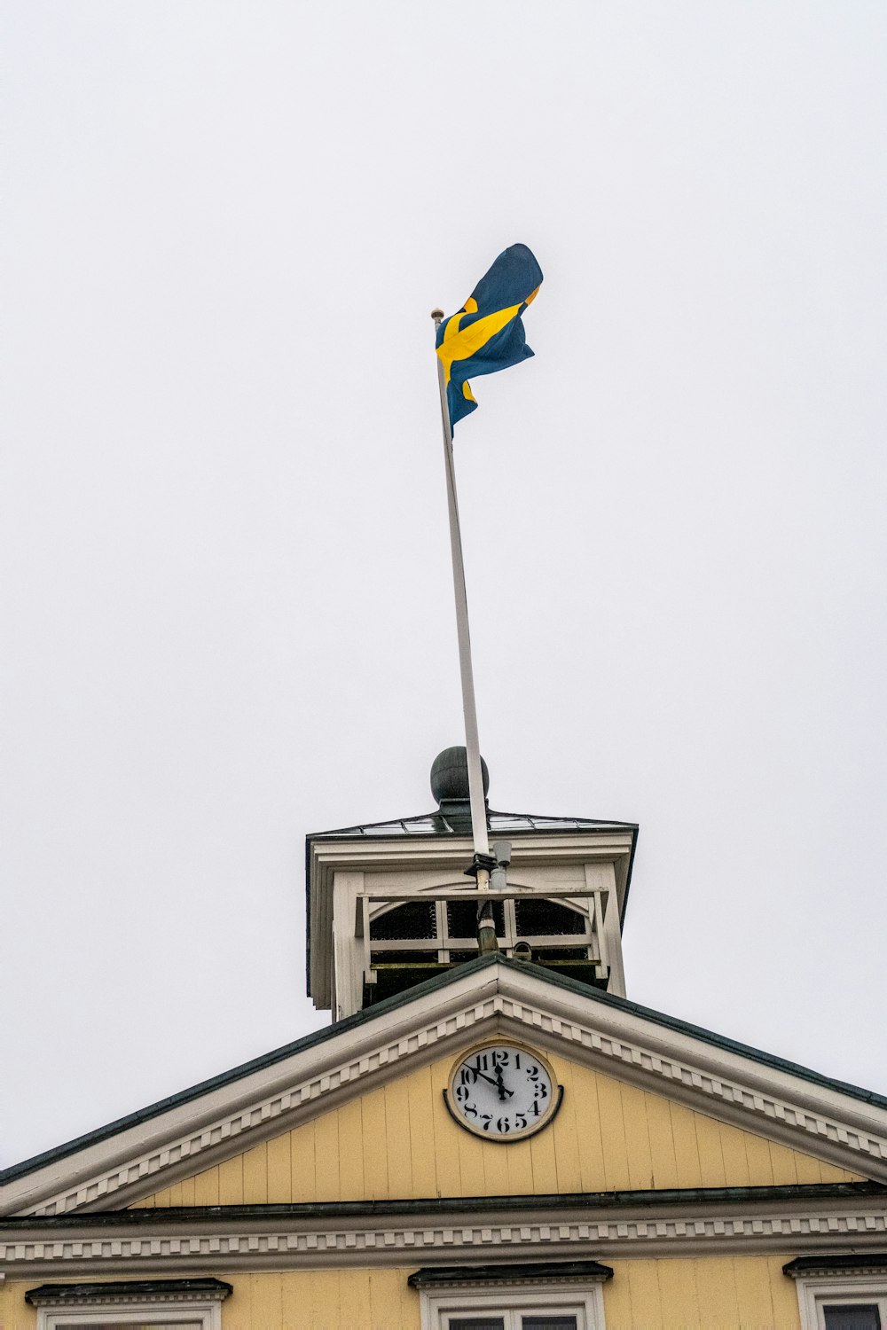 a flag on top of a building with a clock