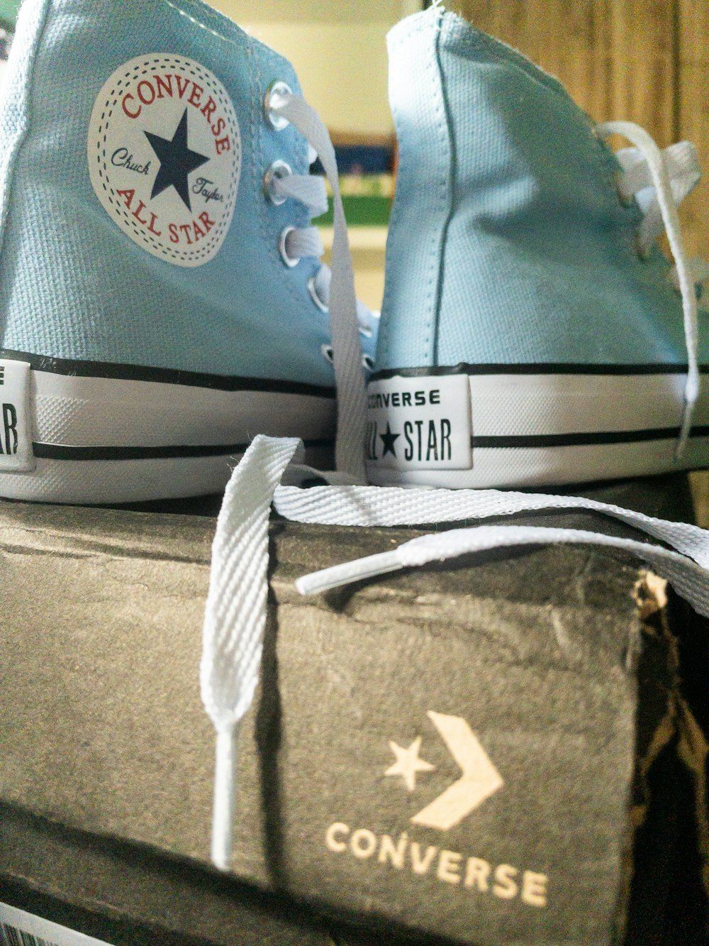 Un paio di scarpe Converse blu sedute sopra una scatola