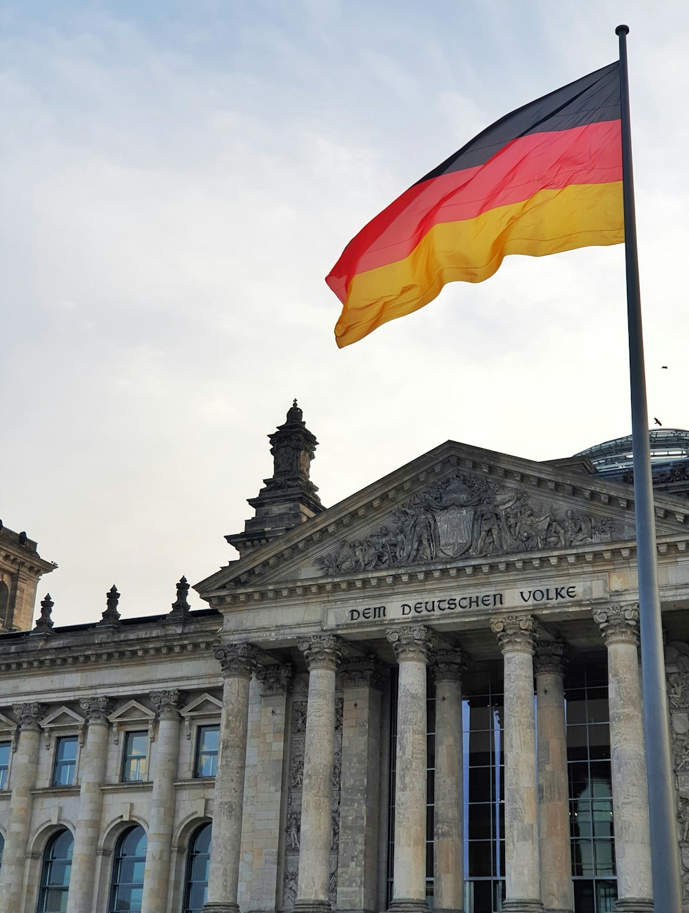 Un drapeau allemand flottant devant un bâtiment