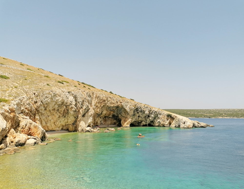 a body of water near a rocky cliff