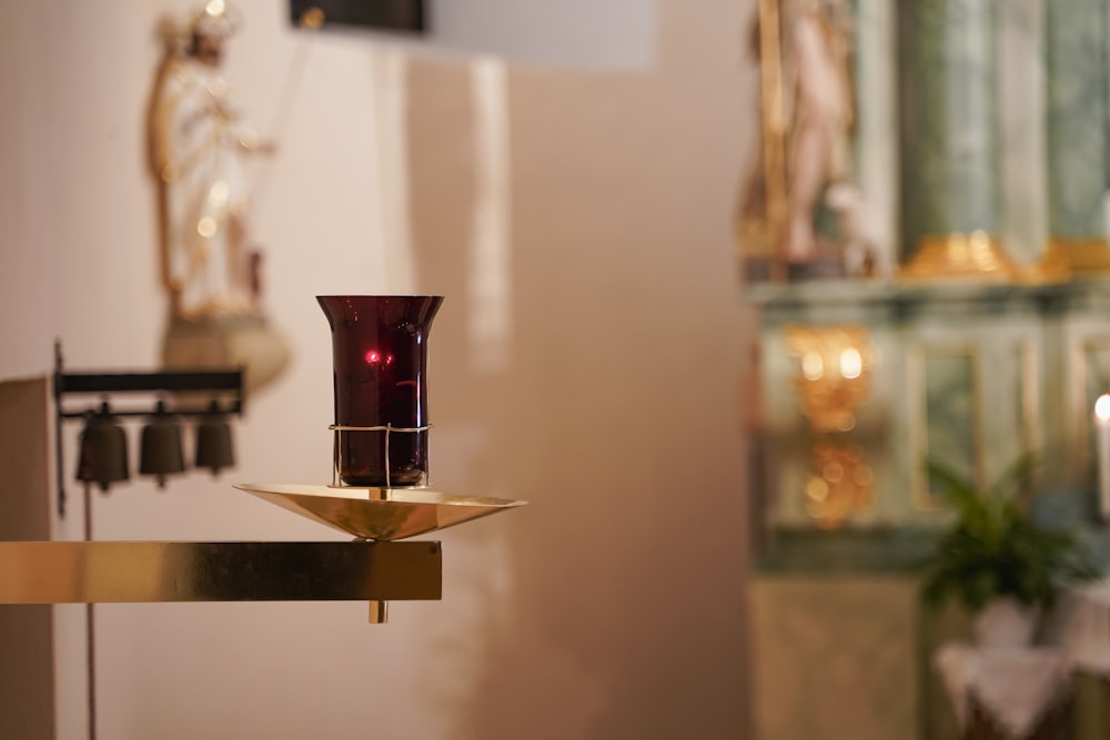 a red vase sitting on top of a table