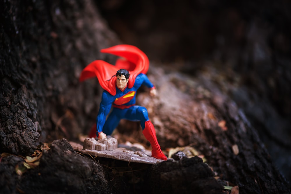 a superman action figure is posed on a rock