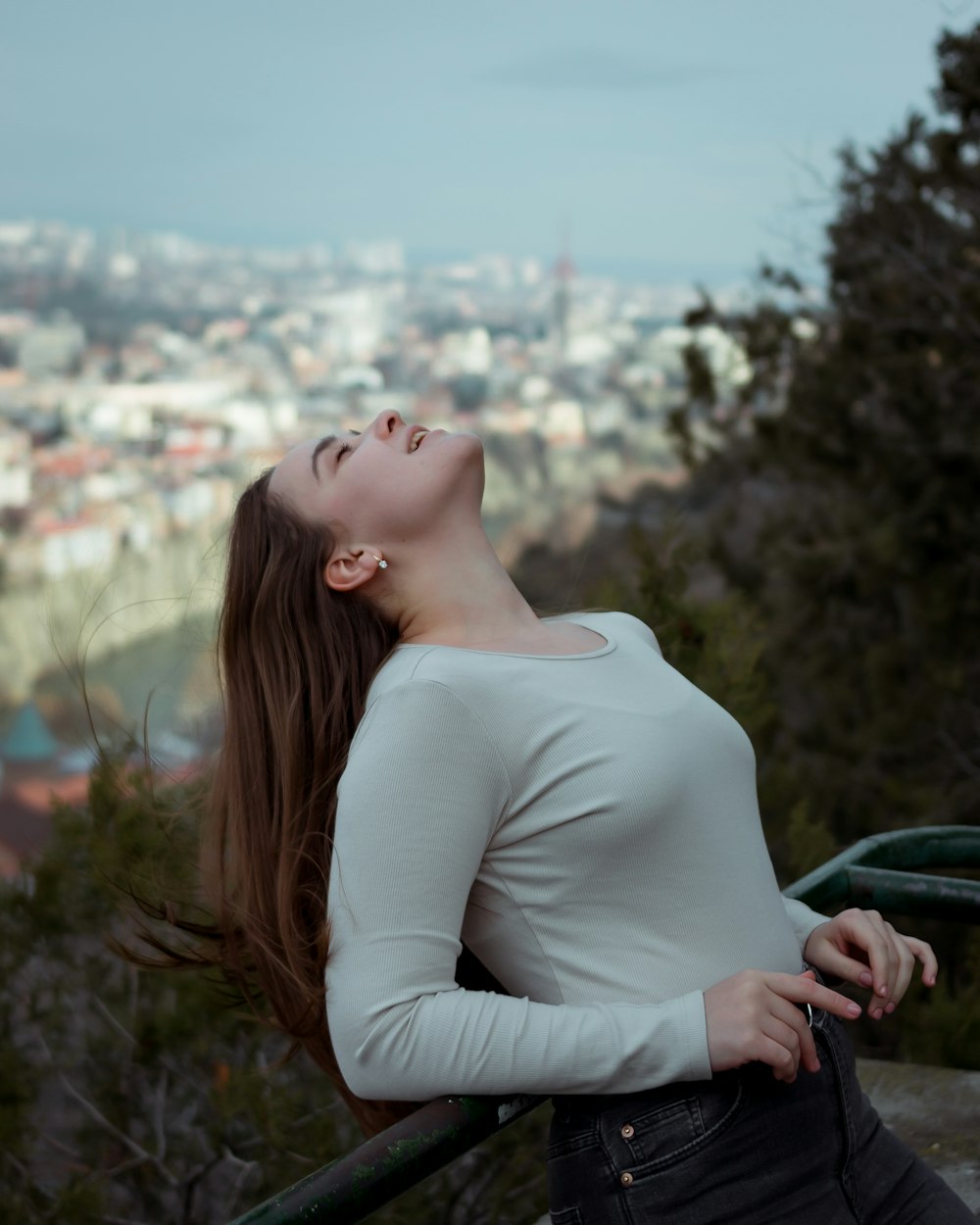 a woman with her eyes closed looking up at the sky