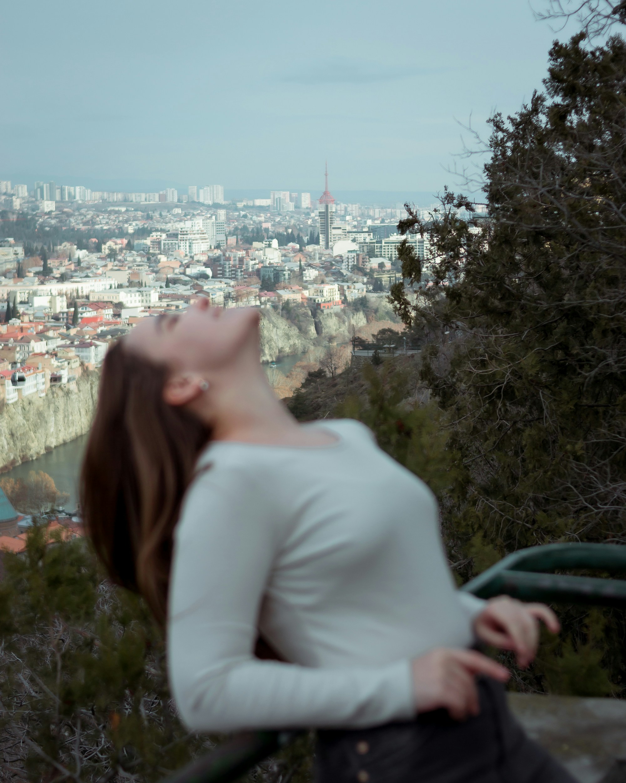 a woman standing on top of a hill with her eyes closed