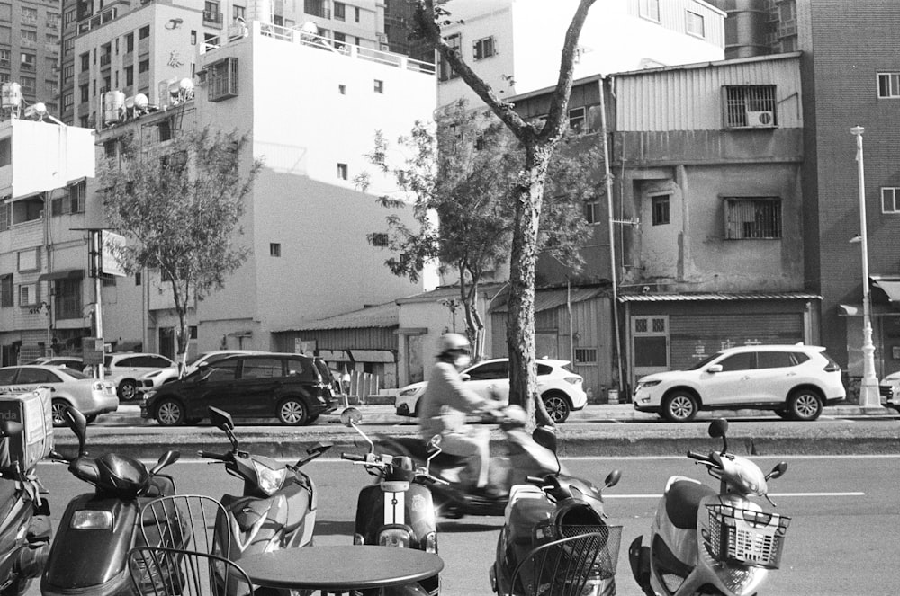 a black and white photo of people on scooters