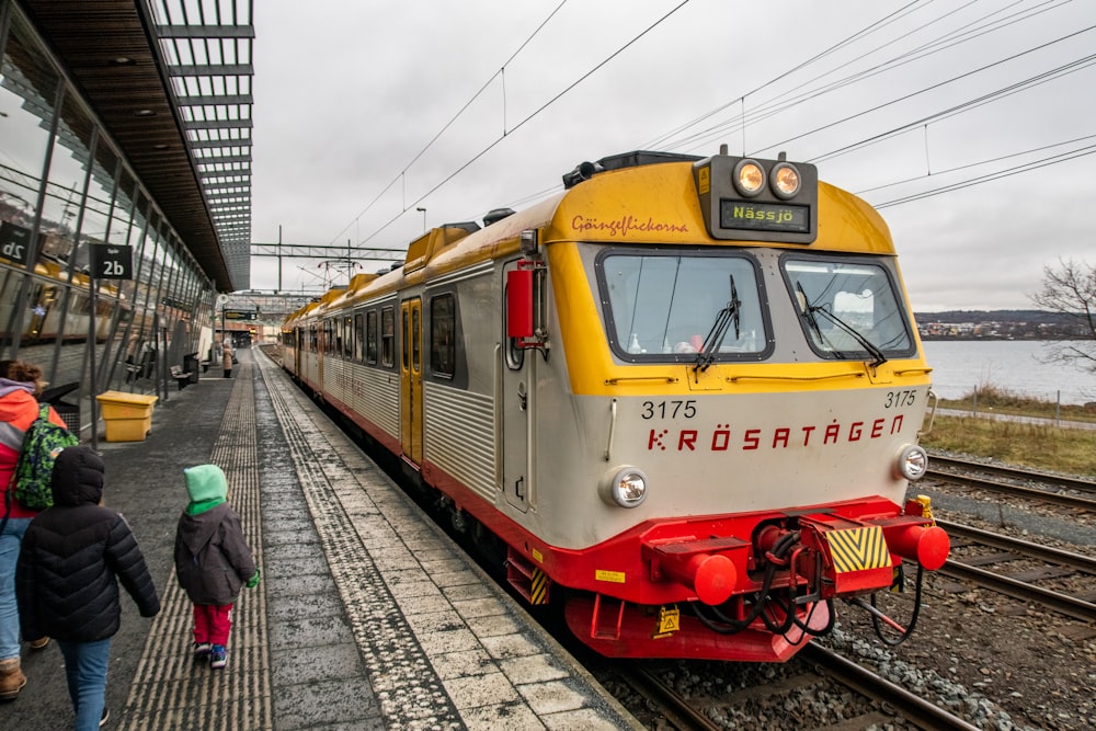 a yellow and white train pulling into a train station
