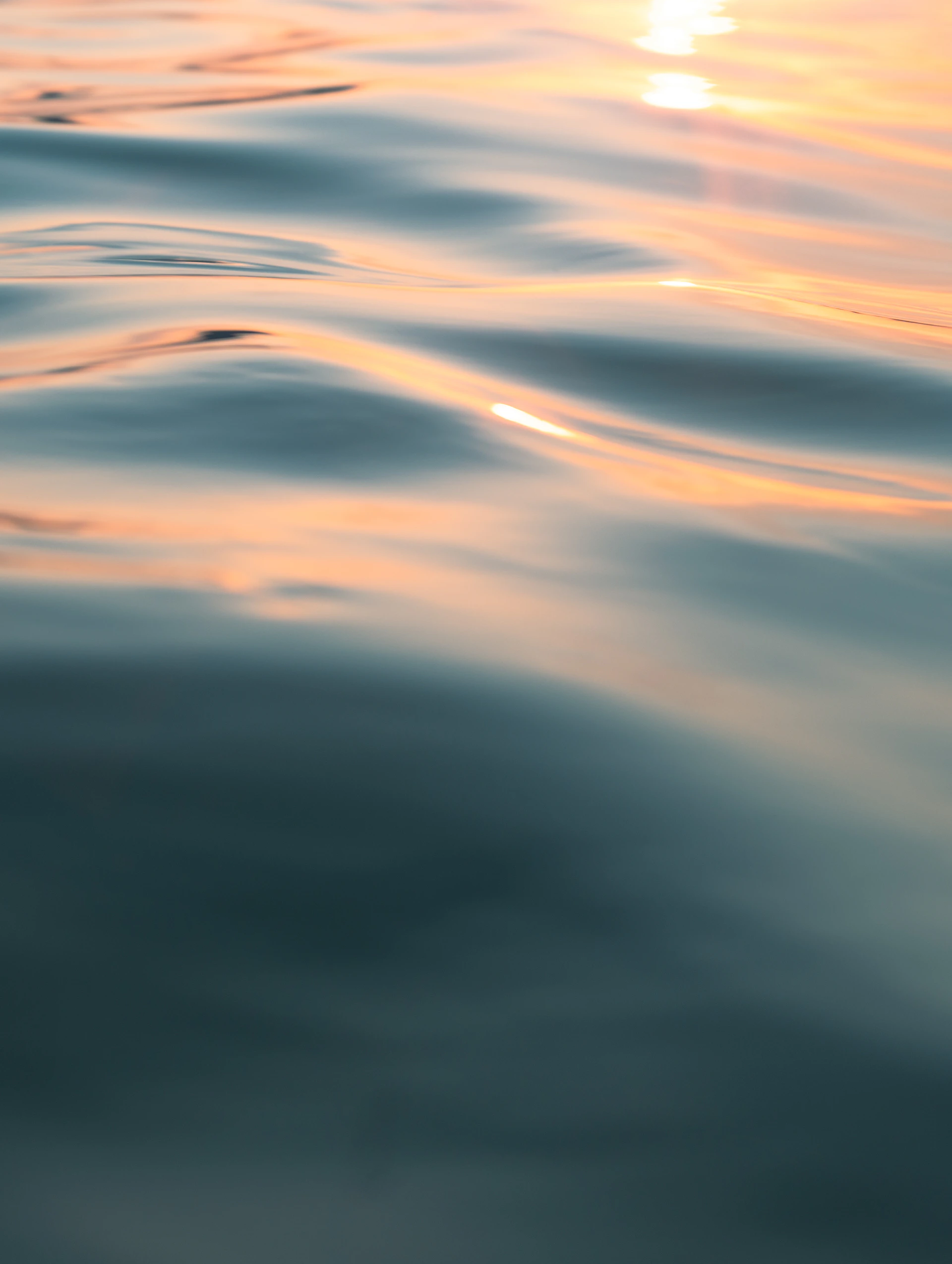 the sun is setting over the ocean water