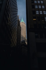 a tall building with a green top in the middle of a city