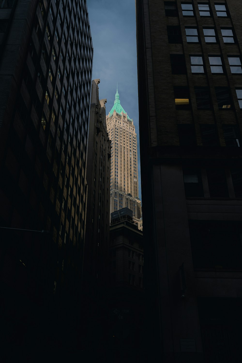 a tall building with a green top in the middle of a city