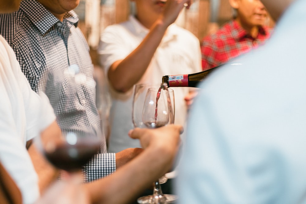 a group of people standing next to each other holding wine glasses