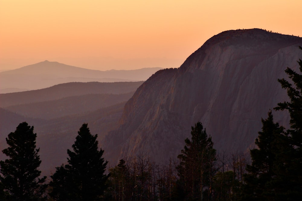 the sun is setting over the mountains in the distance