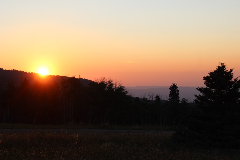 the sun is setting over a mountain range