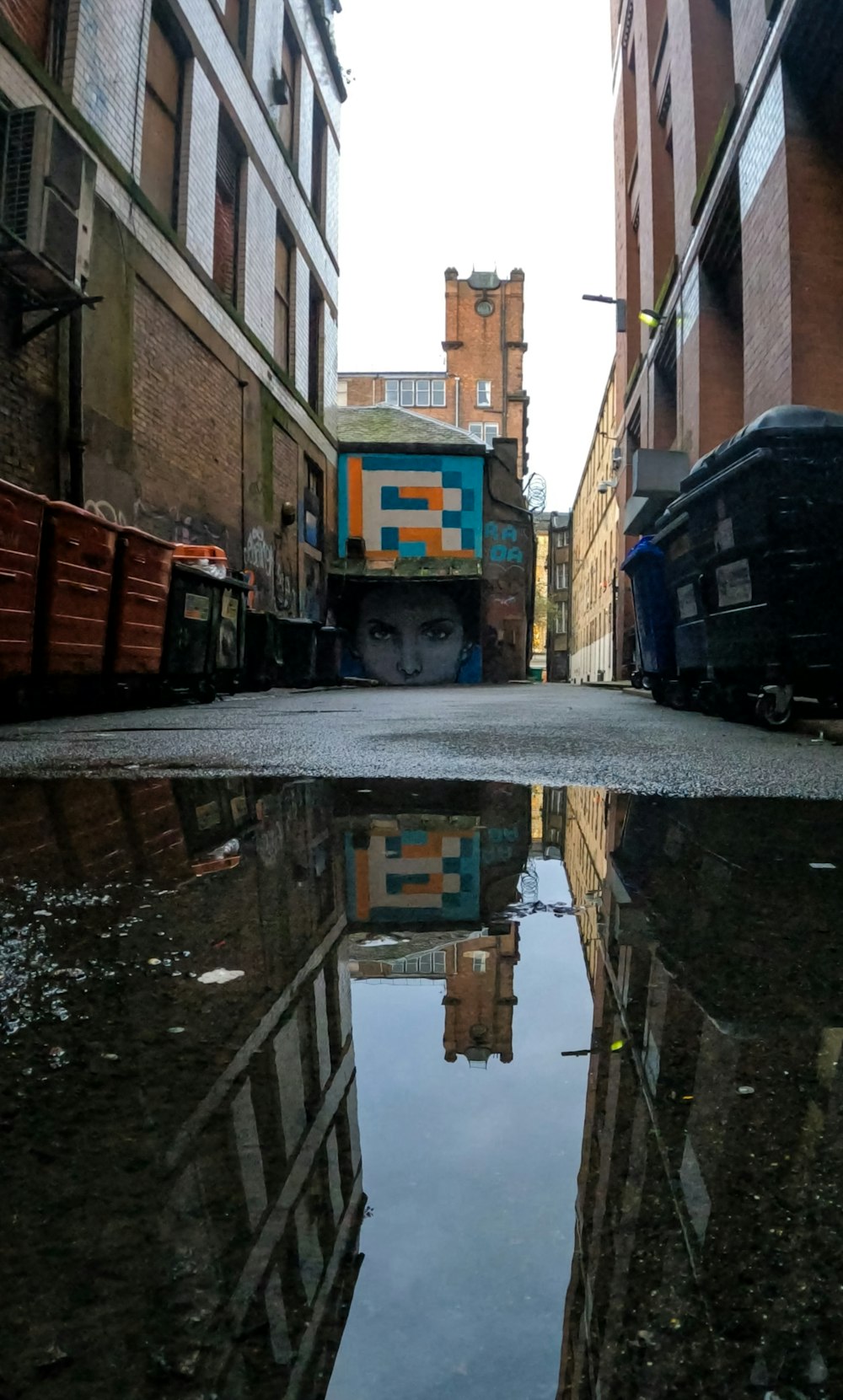 a reflection of a building in a puddle of water