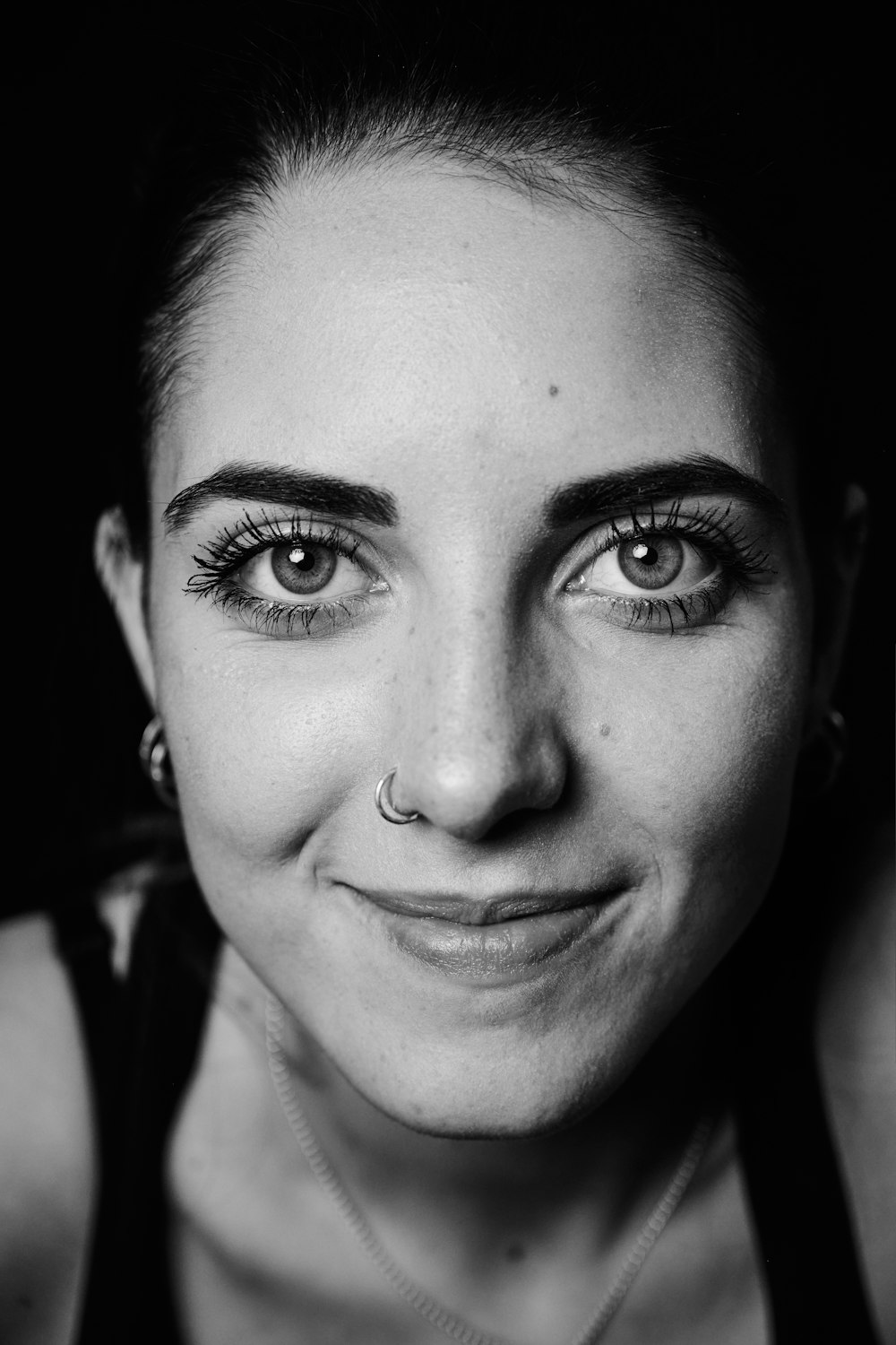 a black and white photo of a woman smiling