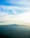 A serene landscape with soft lighting and a distant mountain range.