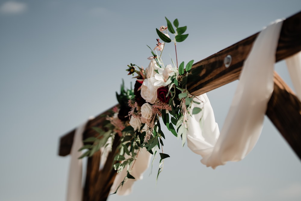 a wooden cross decorated with flowers and greenery