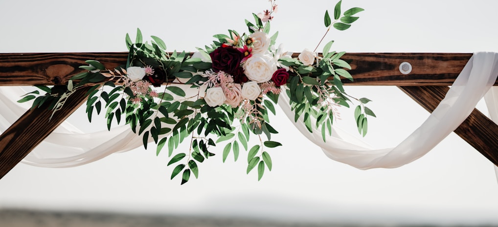 a wedding arch decorated with flowers and greenery