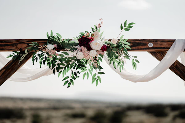 Arco de ceremonia decorado con flores y ramas verdes