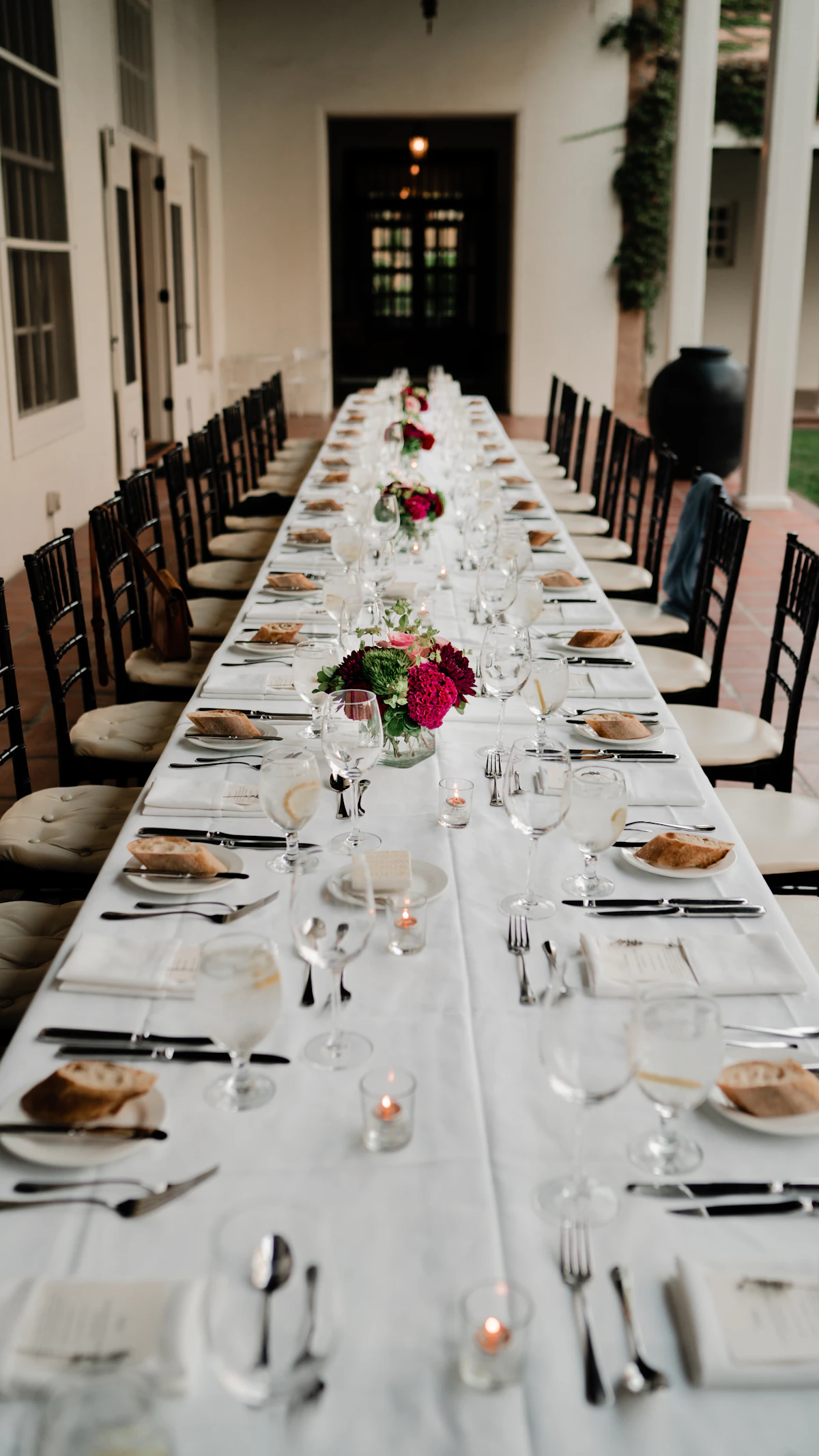 A long outdoor table laid for many, late golden light falling across the plates.