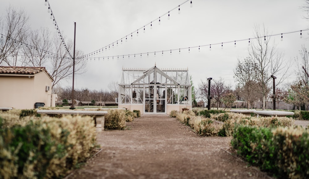 a walkway leading to a building with a glass house in the background