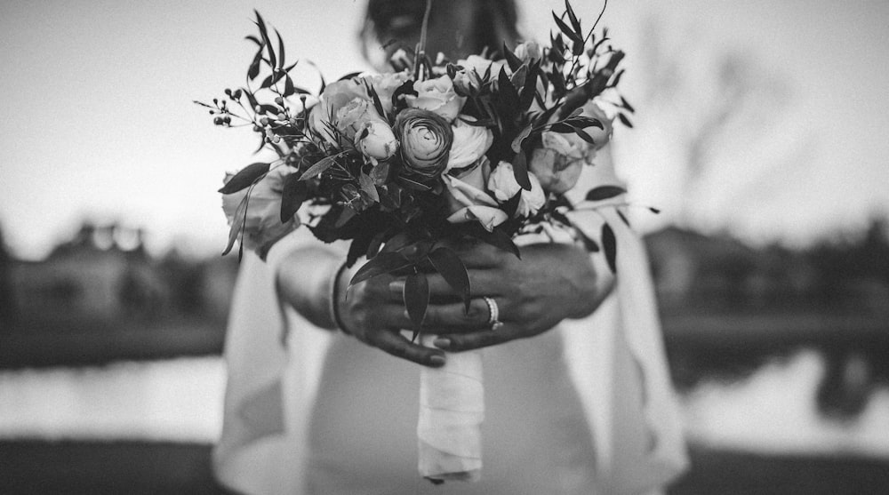 a woman holding a bouquet of flowers in her hands