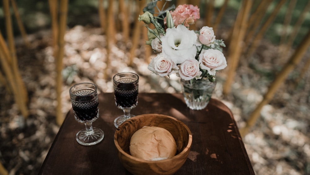 a wooden table topped with two glasses of wine