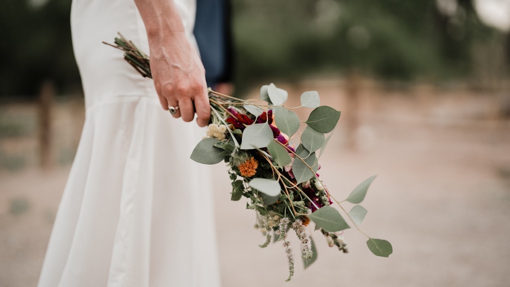 a close up of a person holding a bouquet of flowers