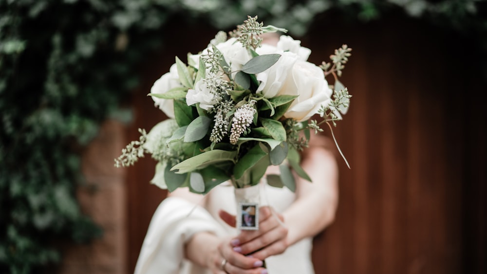 a person holding a bouquet of flowers in their hands