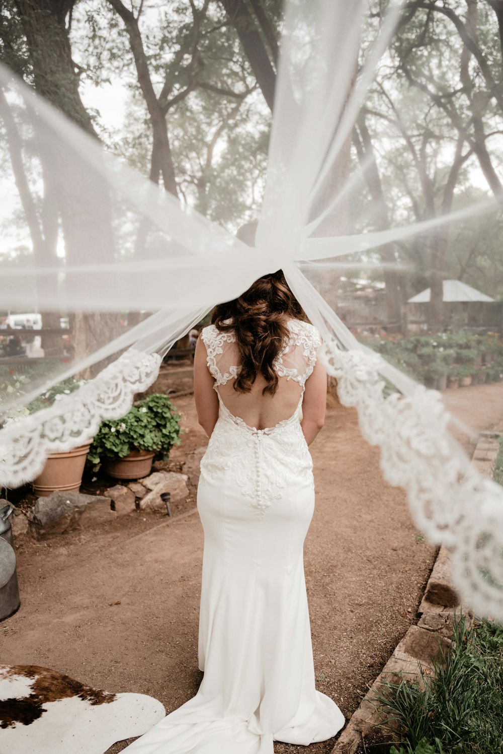 a woman in a wedding dress standing under a veil