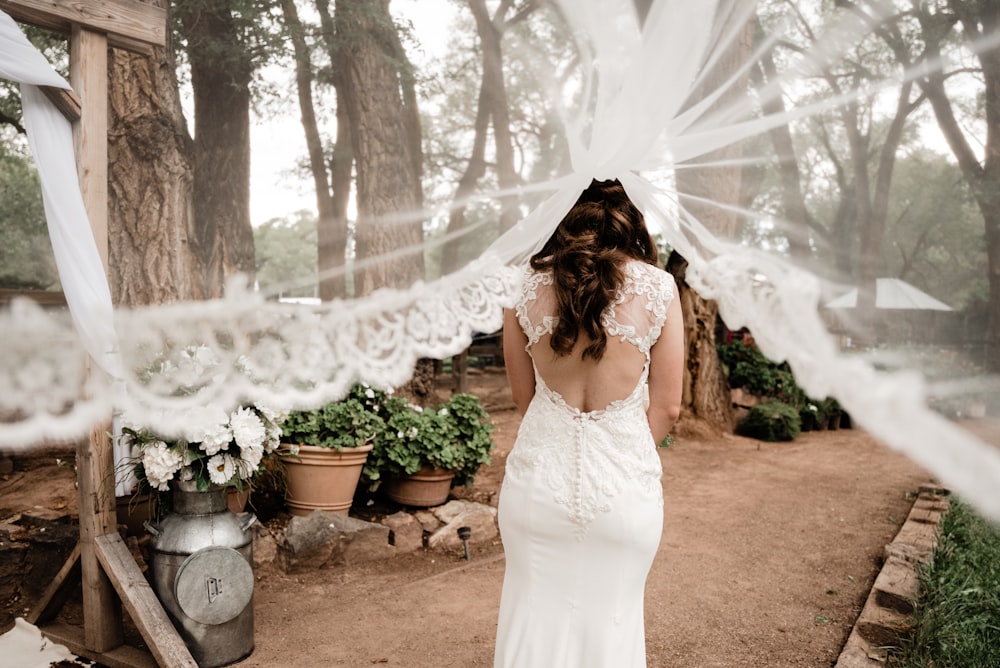 a woman in a wedding dress standing under a veil