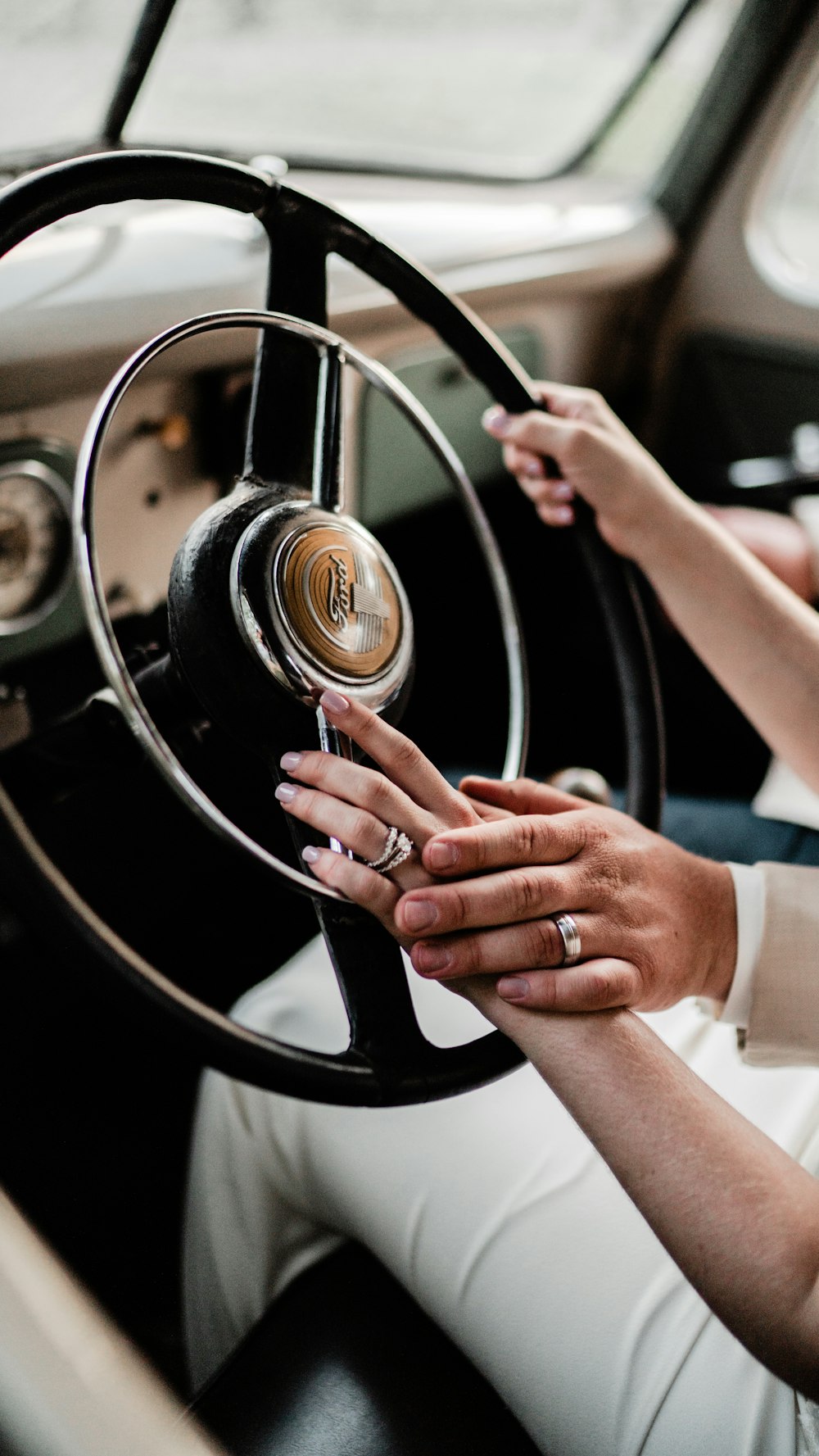 a woman driving a car with her hands on the steering wheel