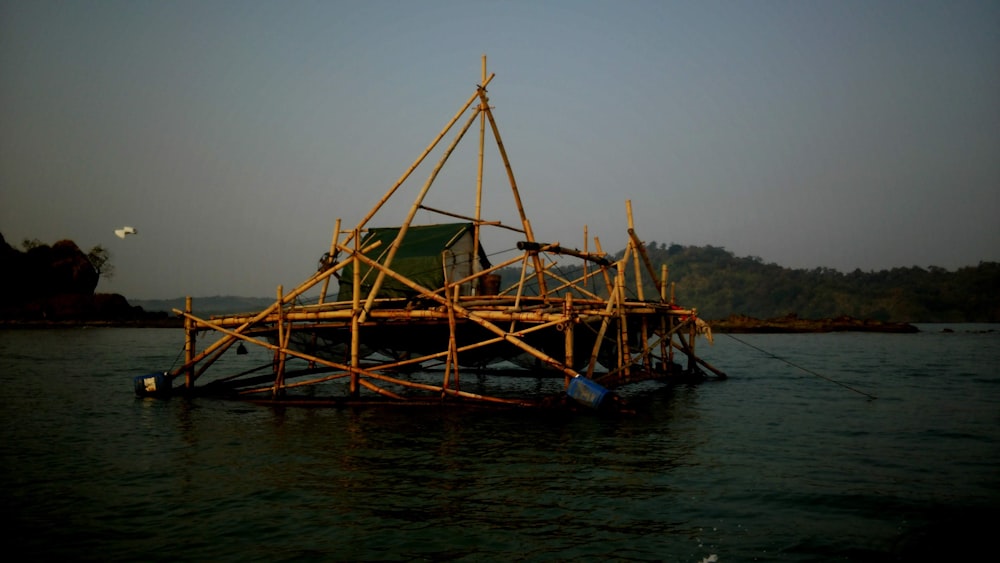 a wooden structure floating on top of a body of water