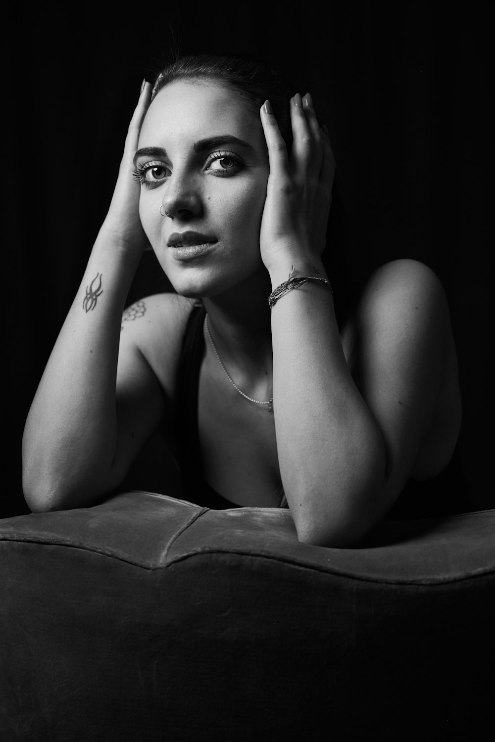 a black and white photo of a woman sitting on a couch