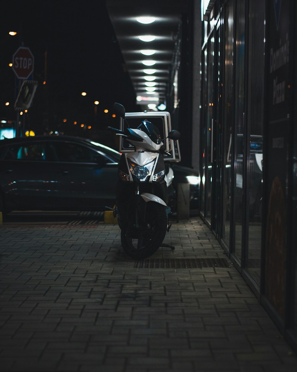 uma motocicleta estacionada em uma calçada ao lado de um prédio