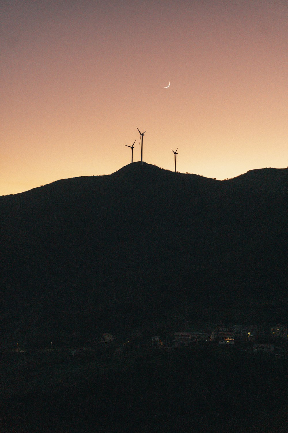 a hill with three windmills on top of it