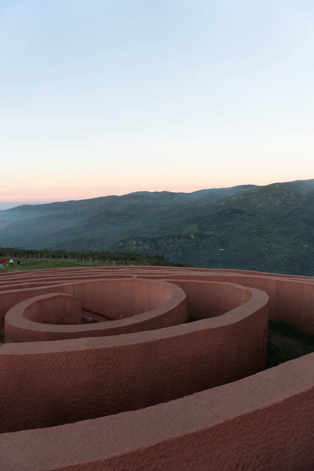 a large circular structure with a view of mountains in the distance
