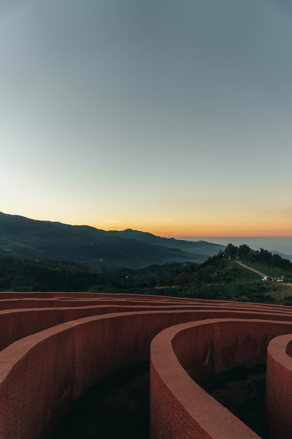 a view of a circular structure with mountains in the background