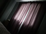 Bedroom window with stylish blackout curtains drawn halfway.