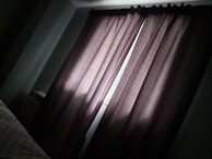 Close-up of blackout curtains blocking sunlight in a cozy bedroom.