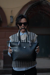 a man holding a black and white bag