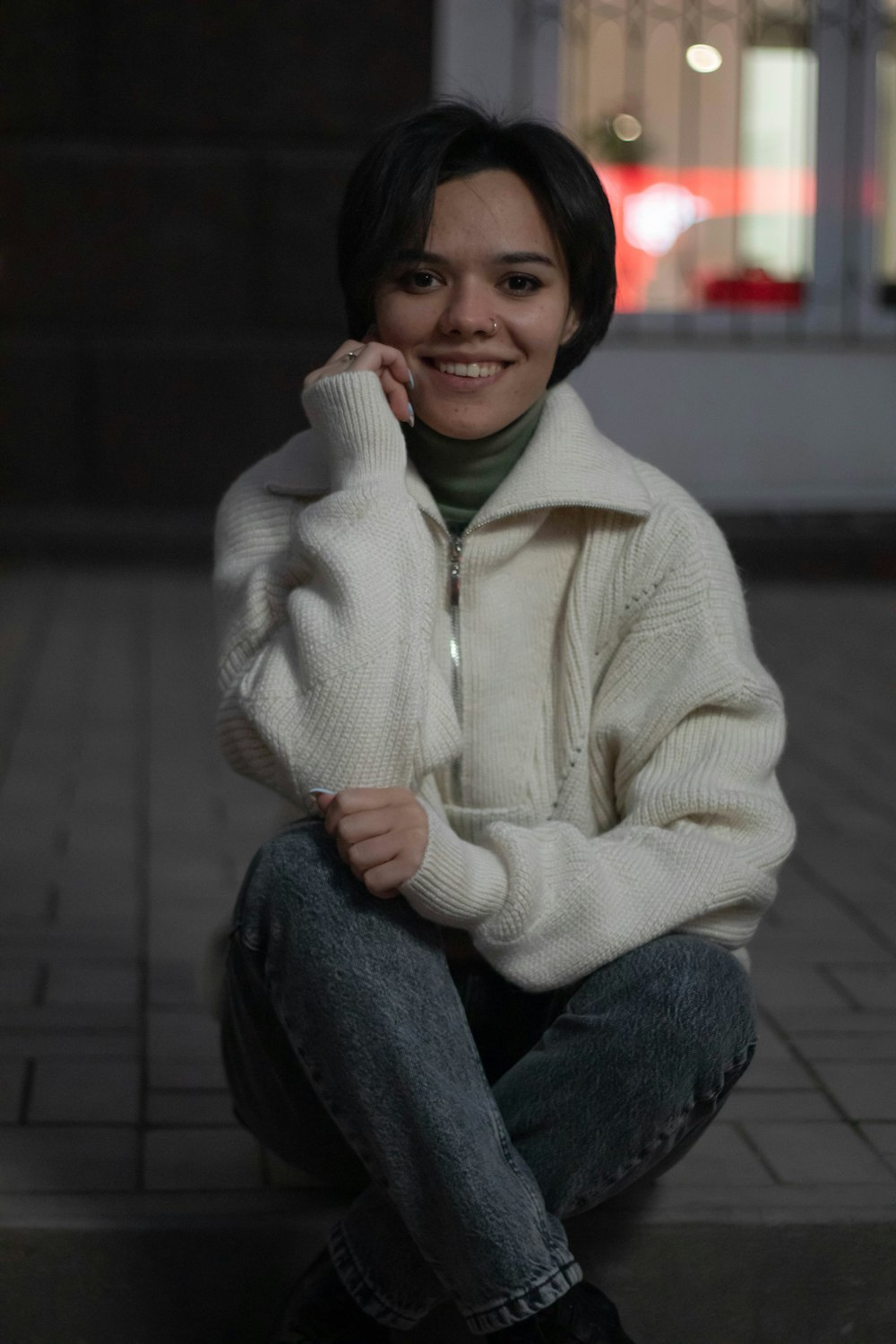 a woman is sitting on the ground smiling