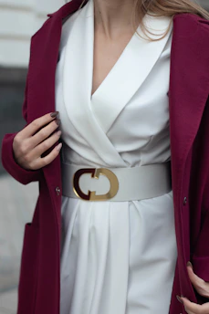 a woman wearing a white dress and a burgundy coat